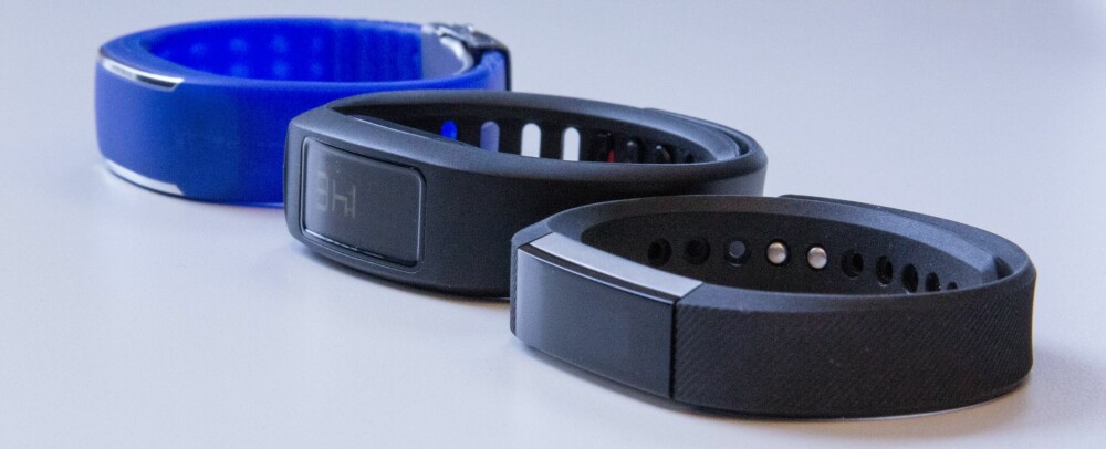 MINDRE: Fitbit Alta er mindre, letter og slankere enn mange av konkurrentene, som Garmin Vivofit 2 (midten) og Polar Loop (bak).