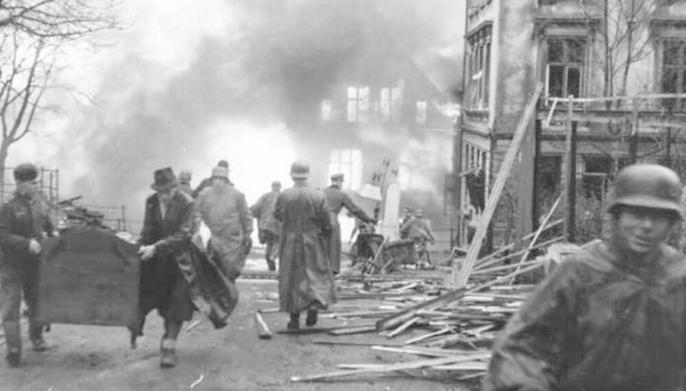 Eiendeler bæres vekk fra flammene i en sønderknust Bergen by 20. april 1944.