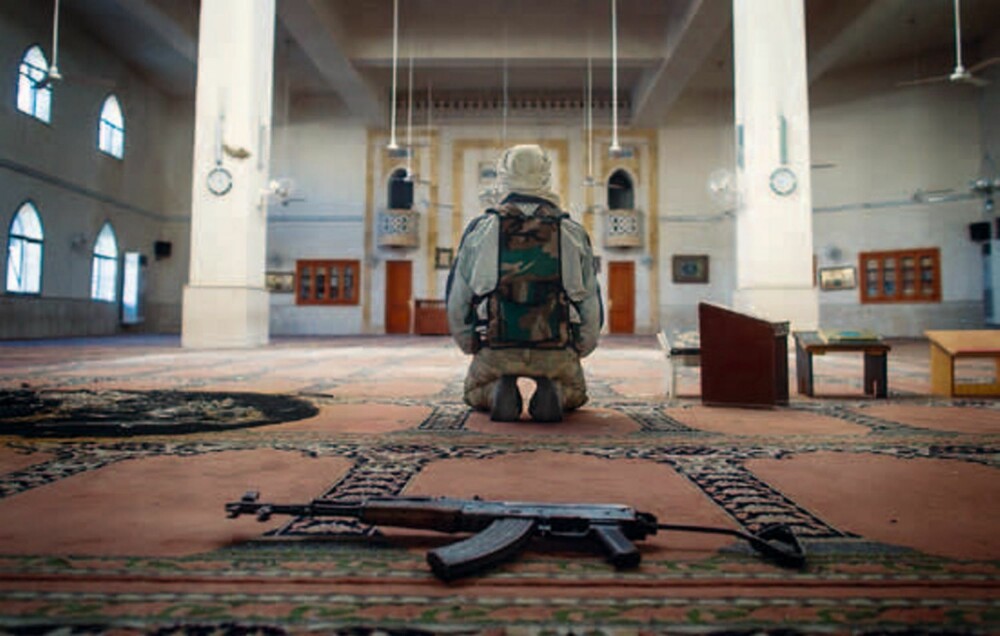 Bønn: En opprørssoldat ber i en moské i Aleppo.