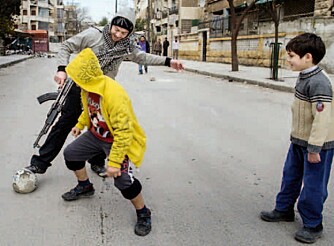 Hverdagsliv: En opprørssoldat spiller fotball med lokale gutter i et nabolag i sentrum.