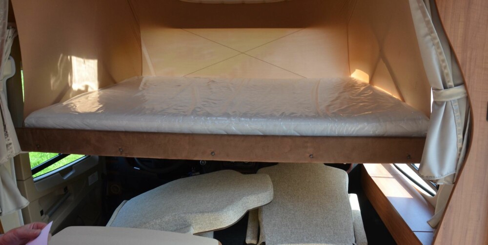 SENKESENG: Den store sengen foran viser hvorfor frontruten har bratt vinkel. Her kan man lese en avis uten å skalle i taket.