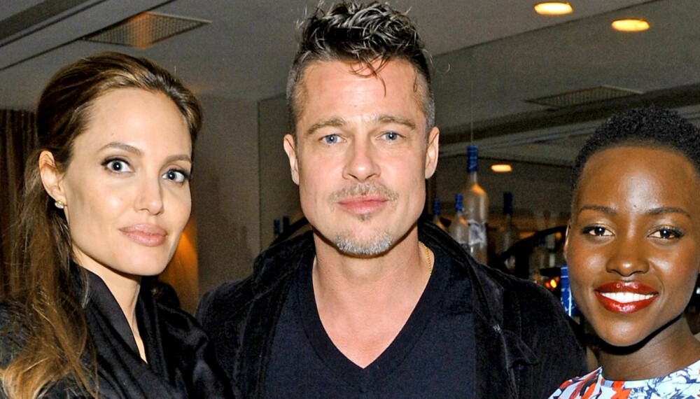 ANSTRENGT: Trioen stilte opp på bilde sammen på en middag i Hollywood i mars. Angelina Jolie så ikke spesielt komfortabel ut der hun stod ved siden av Brad Pitt og en strålende blid Lupita Nyong'o.