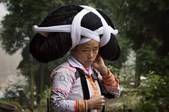Xiong Guaang Chin har pyntet seg med fem kilo hår hun har arvet fra familiens eldre kvinner. Tidligere arbeidet de i åkeren med denne svære frisyren, men i dag brukes den bare ved spesielle anledninger.