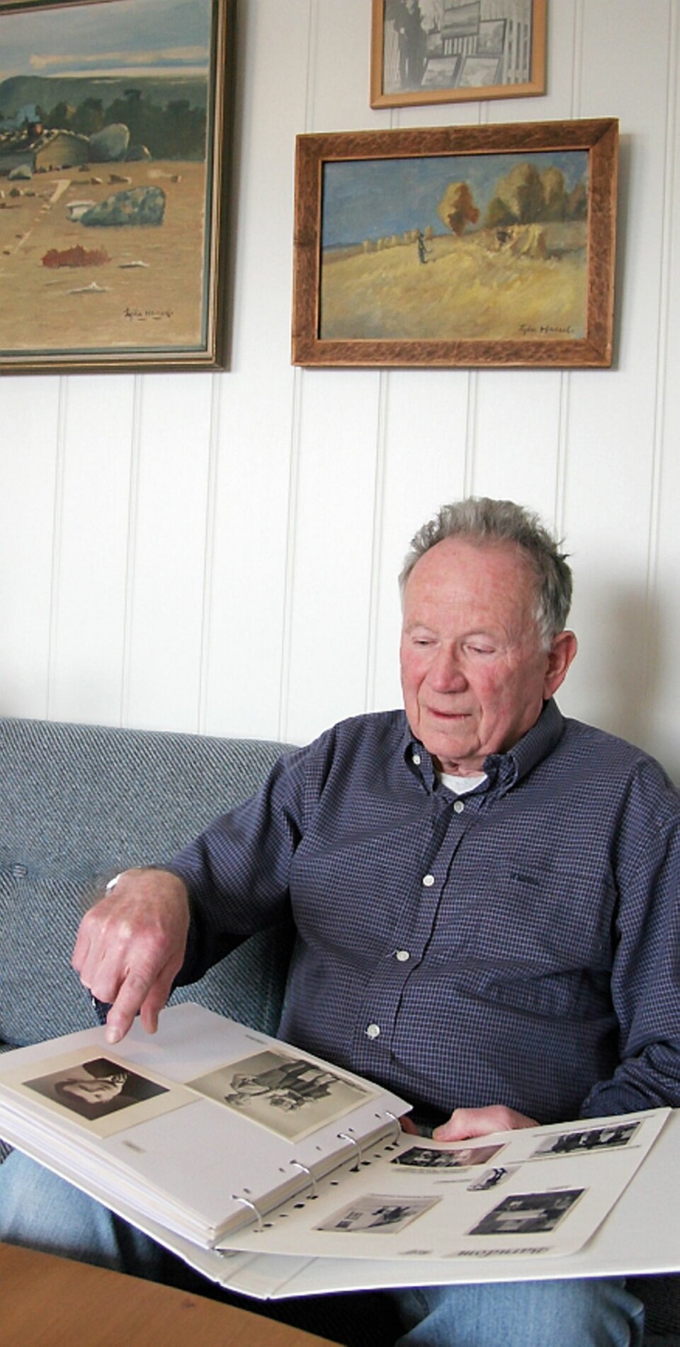 Rolf Hassel er Lyders nevø og en av få som husker onkelen. Her med en utklippsbok om saken. På veggen bak henger bilder som Lyder har malt. Han var også kunstmaler.