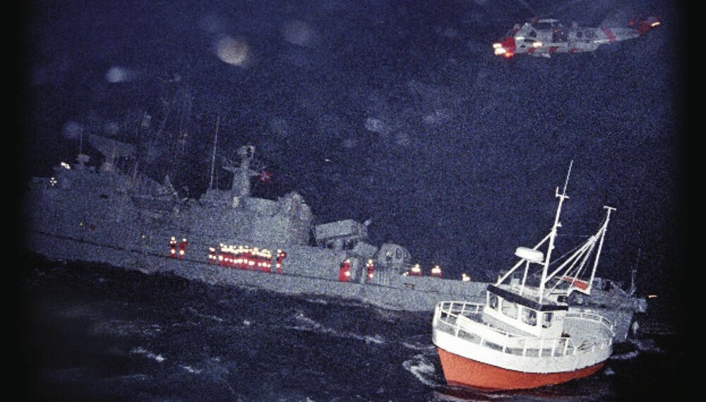 KNM Oslo har grunnstøtt. Mannskap ikledd overlevelsesdrakter evakueres. Små fiskeskøyter bidrar i hjelpearbeidet. Et Sea King-helikopter svever over havaristen i stormkastene.