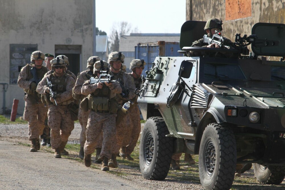 Marinesoldatene rykker fram bak et av Fremmedlegionens lettpansrede kjøretøy.