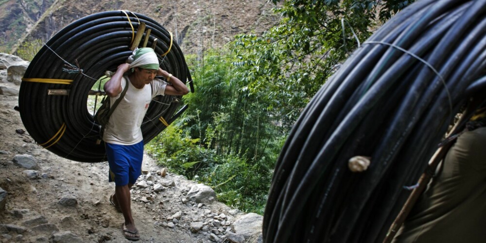 Jeg veide aldri disse buntene med vannledning, men fikk høre senere fra flere hold at de veier hver seg omtrent 85 kilo. Og disse to sherpaene, som bærer vannledningene til en landsby sentralt i Nepal, bar denne børen i flere dager for å komme dit de skulle.