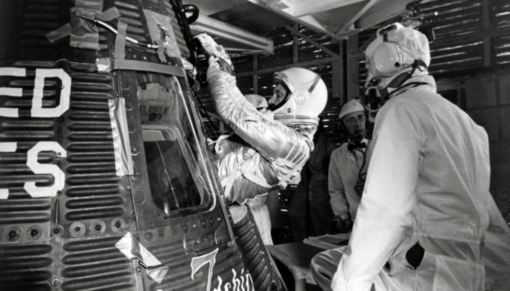 Glenn på vei inn i Mercury-romfartøyet Friendship 7. Tapebitene på kapselen ble fjernet før oppskyting...