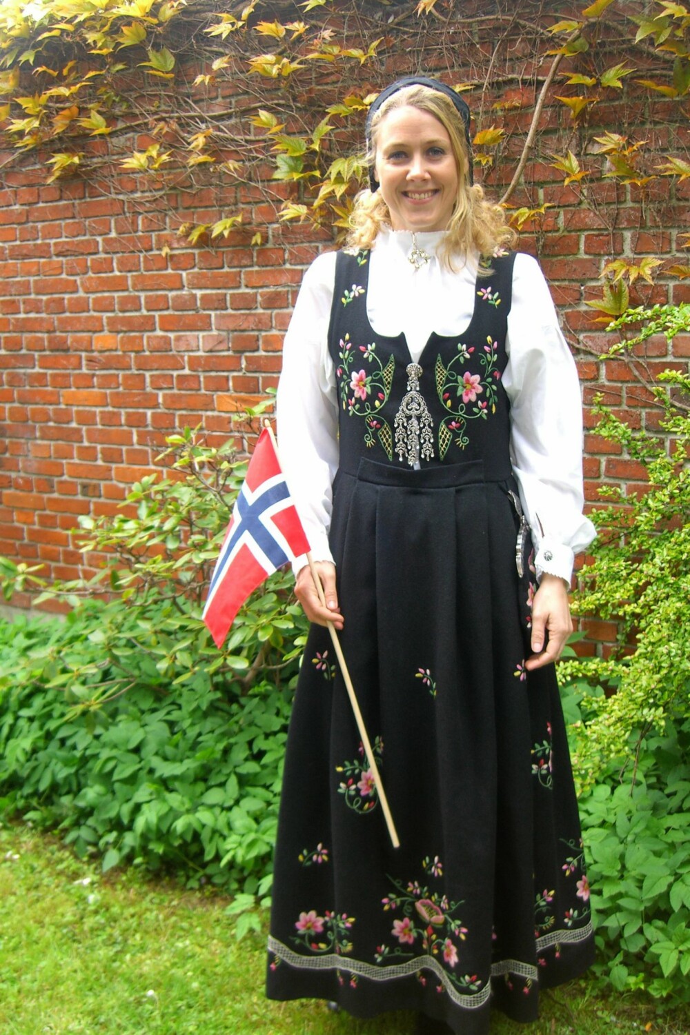 LUNDEBYDRAKT: Hilde Svendsen lot flagget vaie i vinden i sin fine Lundebydrakt i går.