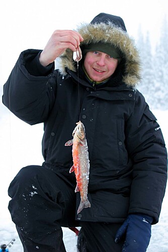 Fornøyd fisker med røye tatt på blink. Foto: Henrik Strømstad