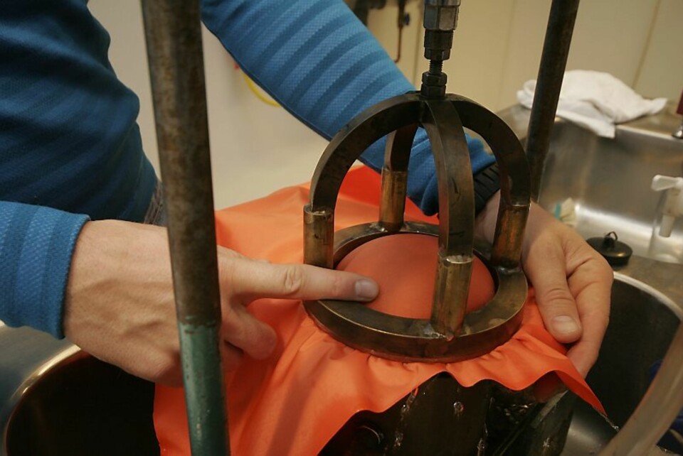 SJEKKER VANNTETTHET:Stoffet settes under vanntrykk nedenfra, til det buler en stor kul i prøven. Øyvind måler hvor mye trykk han må sette før vannet trenger gjennom.