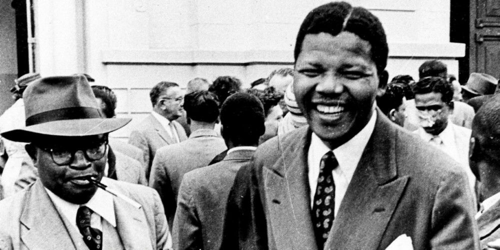 YNGRE AKTIVIST: Her er Nelson Mandela på vei ut av rettsalen hvor han er tiltalt for høyforræderi. Bildet er tatt i 1958. Sakne mot han og de andre ANC-medlemmene blir senere avvist.