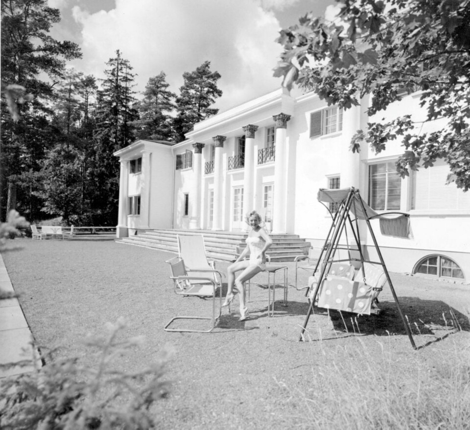 Sonja Henie poserer i stroppeløs badedrakt utenfor det praktfulle hjemet sitt Granholtet på Landøya.
