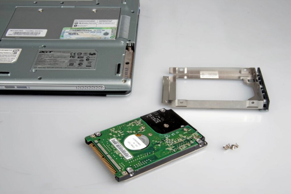 11. Skru harddisken ut av monteringsrammen, men merk hvilken vei den satt. monter den ny e harddisken i rammen, og skyv det hele på plass i PC-en igjen. Skru i skruene. 11. Skru harddisken ut av monteringsrammen, men merk hvilken vei den satt. monter den ny e harddisken i rammen, og skyv det hele på plass i PC-en igjen. Skru i skruene.