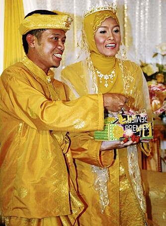 Tradisjonen tro, er alle muslimske brudepar kledd i gult. Her kaster Asliza og Mohd Faizal sukkertøy til barna etter vielsen i Kuala Selangor.