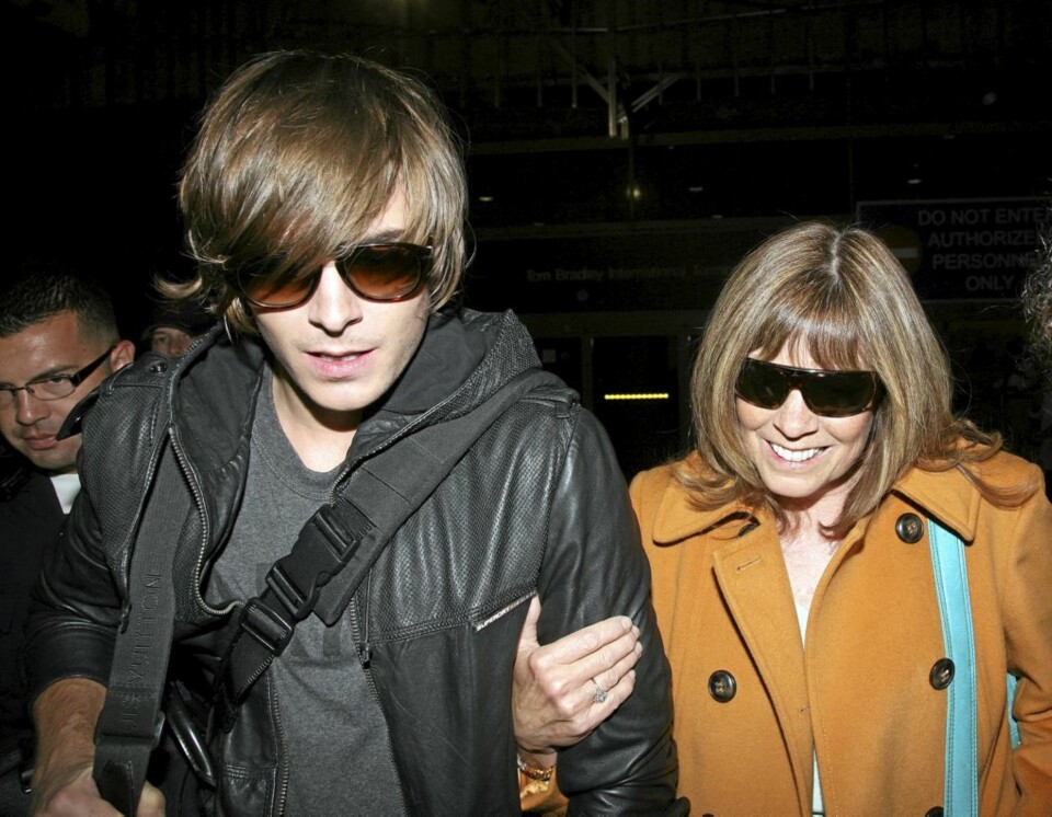 Zac og moren omringes av fotografer på LAX.