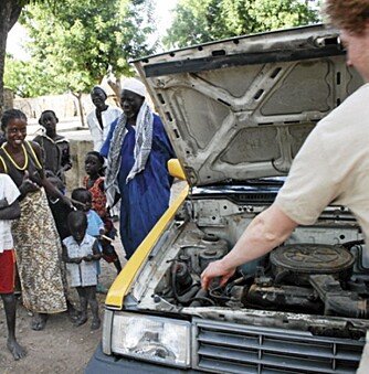 LANGT FRA VEIEN: PÅ vei fra Dakar til Banjul må vi kjøre ut på savannen for å stanse vår kokende bil. Landsbybefolkningen lurer på hvem vi er og hva vi driver med.
