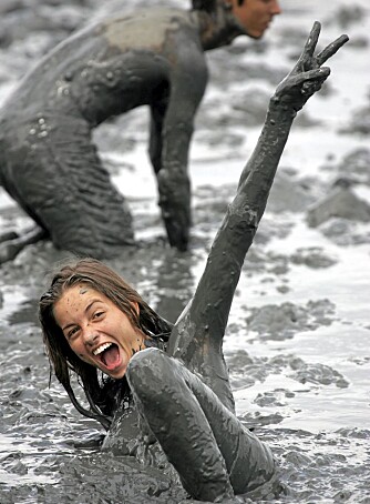 PARATY: I byen Paraty i Brasil feires det også karneval. Her feirer deltakere med å kaste seg ut i et gjørmebad.