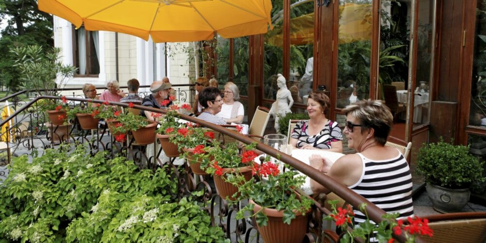 I DET GRØNNE: Ved lunsjtid samler gjestene seg på den vakre terrassen.