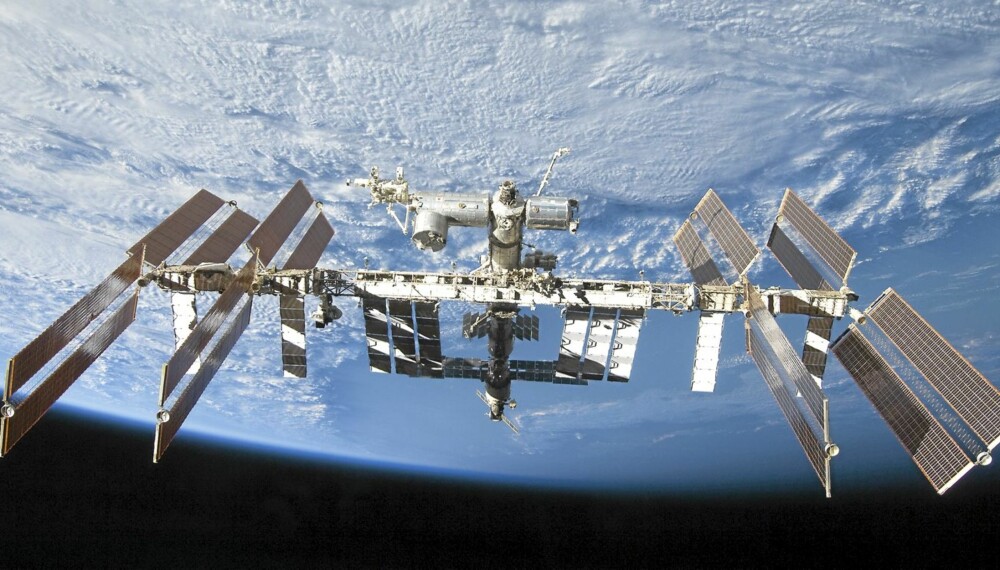 ROMKJEMPE:Slik så den internasjonale romstasjonen ut da STS-128 mannskapet, inklusive Christer Fuglesang, forlot utposten i september 2009. Stasjonens lengdeakse ser nærmest vertikal ut på bildet, med hovedsakelig russiske seksjoner nederst, i skygge, og amerikanske/internasjonale øverst. Nær toppen stikker den europeiske laboratorieseksjonen Colombus ut til høyre, den japanske Kibo laboratorie- og logistikkseksjonen til venstre. Det tverrgående rammeverket domineres av solvinger og varmeveksleflater. Lengden fra tipp til tipp er 108,5 m, et tall som skulle gi en pekepinn om de store avstandene astronauter av og til må bevege seg når de har arbeidsoppgaver utenfor. Romfergen Discovery har vært tilkoblet øverst, det vil si lengst fremme i fartsretningen. Banehøyden er ca. 350 km.