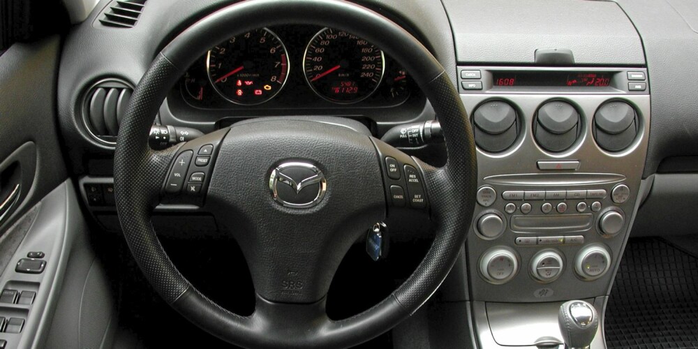 Mazda 6 stasjonsvogn 2002 har mye plastpreg på dashbordet, men det er ryddig.