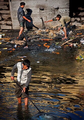 Tre gutter vandrer i den hellige Bagmati-eleven ved Pashupatinath. Kanskje finner de noe de kan bruke eller selge? Søppel, knokler og skitt er det i alle fall nok av ved denne hellige plassen.