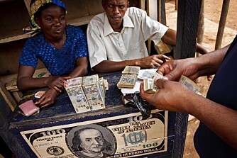 Gatas bank: En pengeveksler på gata i Mambasa. Bunken med penger på bordet er bare en pappboks med sedler limt på utsiden. Men det ser jo imponerende ut.