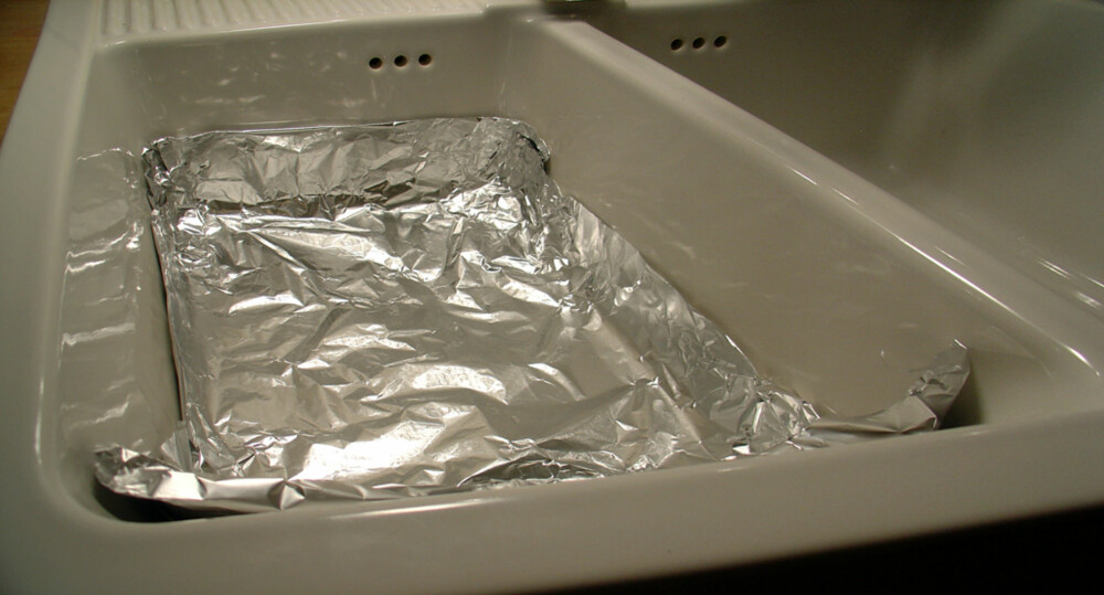 Aluminiumsfolie: Legg folien i bunnen og fyll på med varmt vann. Aluminiumsfolie: Legg folien i bunnen og fyll på med varmt vann.