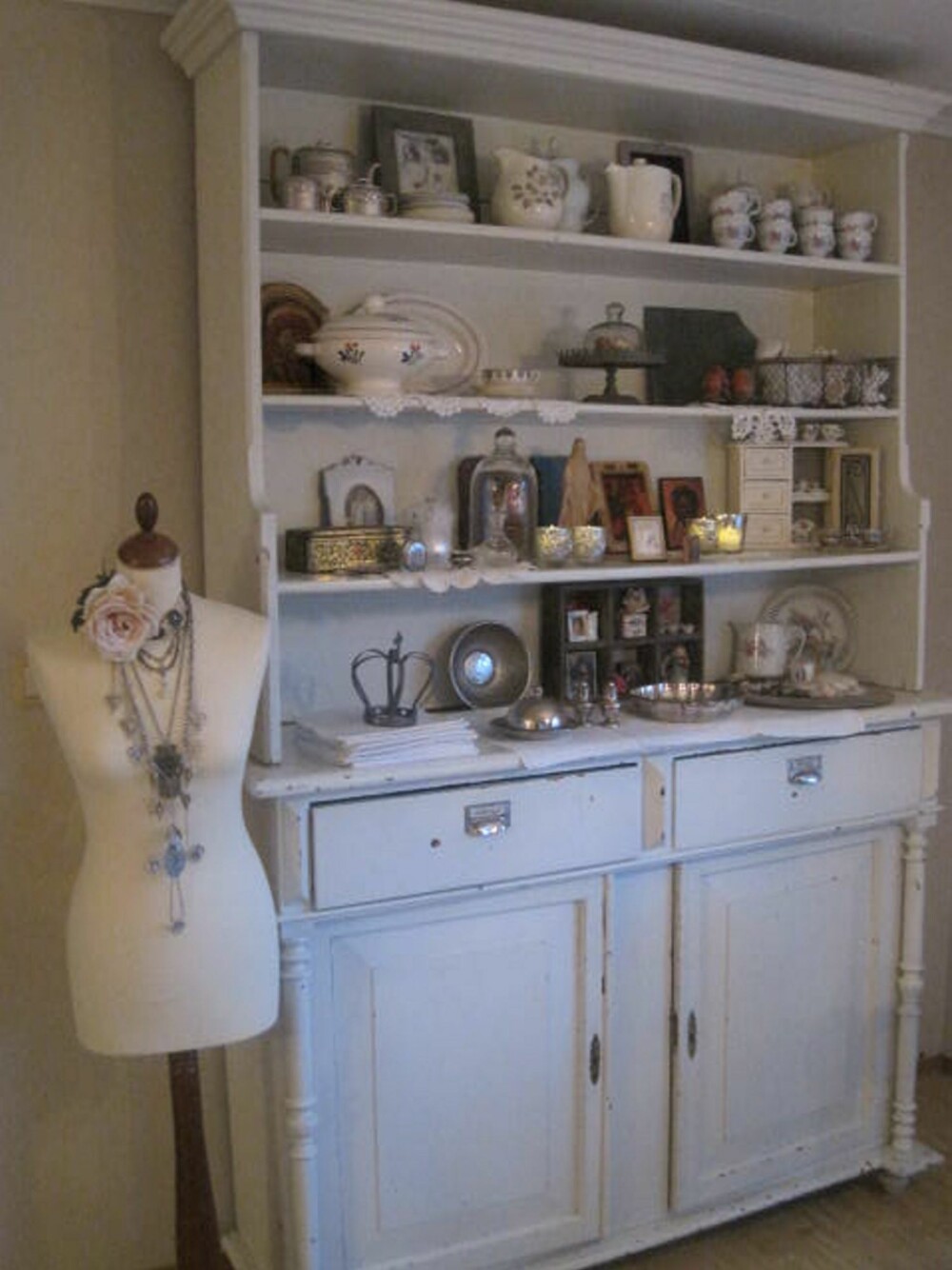 I stuen står en samling med gammelt porselen og andre bruksgjenstander utstilt.