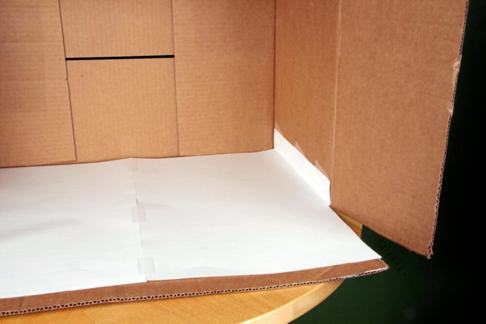 1 Tape sammen ark til å fylle bunnen av kassen. Brett kanten av arket for å skape overlapp i hjørnene. Skjær til slik at klaffene på esken kan beveges fritt. Gjør det samme i taket av boksen.