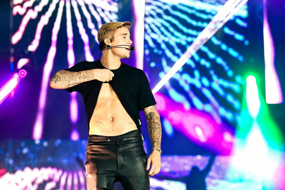 Justin Bieber viser magen på scenen. 