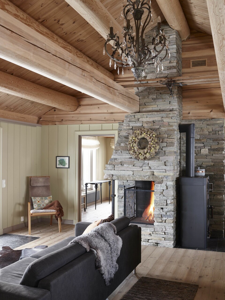 SOLID TAKHØYDE: Det flotte åstaket har 23 store stokker. Peisen er tørrmurt i det som kalles råkopp av oppdalsskifer. Innvendig kledning er Skjåkpanel og gulvet er fra Norrlandsgulv. Ovnen til høyre i bildeter fra Austroflamm. FOTO: Sveinung Bråthen