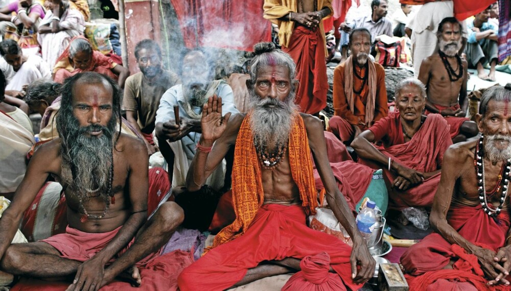 SADHUEN BABA: Med svømmende, glassaktige øyne forteller Baba (i midten) at det å røyke ti hasjpiper om dagen gir deg bedre kontakt med gudene.