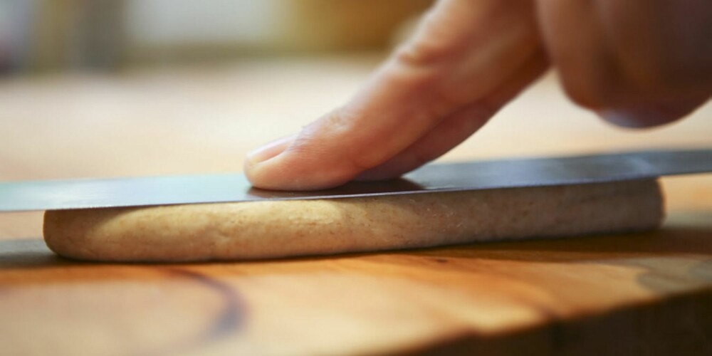 SLIK LAGER DU PØLSEBRØD: Rull deigen sammen til pølser og trykk dem flate med en kniv eller en palette.