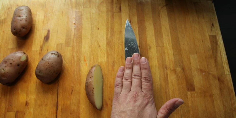 Legg knivbladet flatt på de halve potetene, press dem ned og knus dem.