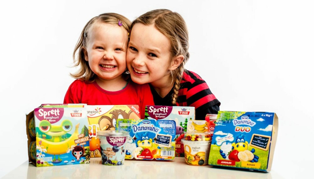 ALLE LIKER YOGHURT: Selma (2) og Agnes (9) er glad i yoghurt, i likhet med de fleste barn. Her viser de alle produktene i vår test av barneyoghurt.