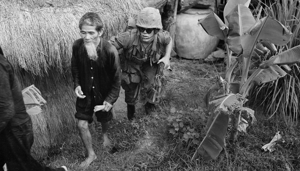 VIETNAMKRIGEN: Bildet viser en amerikansk soldat i et 'Search & Clear'-oppdrag som har fått tak i en eldre mann mistenkt for å hjelpe Viet Cong. Operasjonen foregår noen kilometer vest for Da Nang flystasjon.