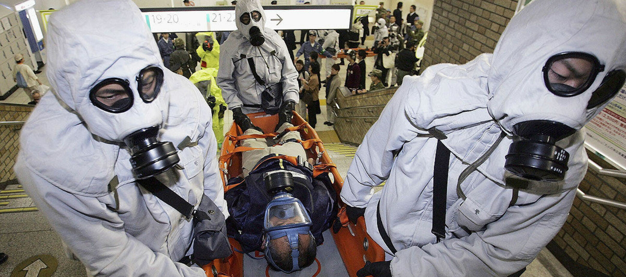 Menn i beskyttelsesdrakter bærer en skadet person i en antiterrorøvelse på Onomiya-stasjonen i Tokyo i 2005. Øvelsen var basert på det samme scenariet som sarinangrepet ti år tidligere.