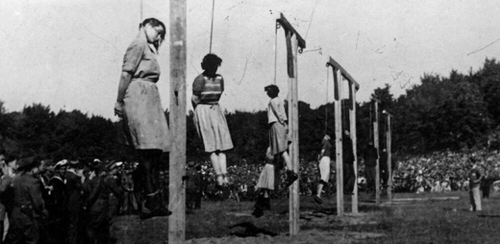 VISTE INGEN NÅDE, BLE SELV DØMT TIL DØDEN: Minst 21 kvinner ble etter andre verdenskrig hengt for grusomheter de hadde begått i tyske konsentrasjonsleirer. Bildet viser fangevoktere ved Stutthof konsentrasjonsleir som blir henrettet den 4. juli 1946 foran tusenvis av mennesker.