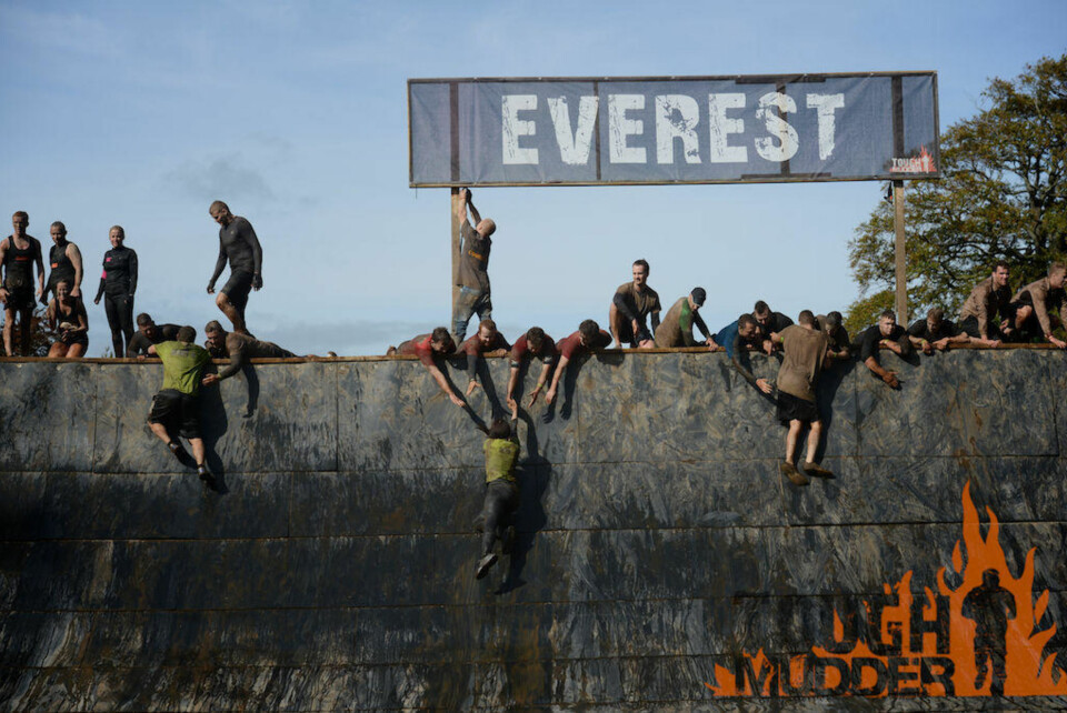 KNALLHARDT: Hindreløypen i «Tough Mudder»er ingen spøk. Her klatrer noen deltakere opp hindretet kjent som «Everest. Quarter pipen er innsmurt med gjørme og fett.