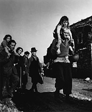 Flyktninger sammen med en amerikansk soldat. Bildet er tatt av den berømte fotografen Robert Capa.