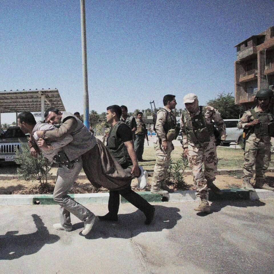 En skadd soldat i den kurdiske kampstyrken Peshmerga blir båret til en bil før han fraktes til et sykehus.