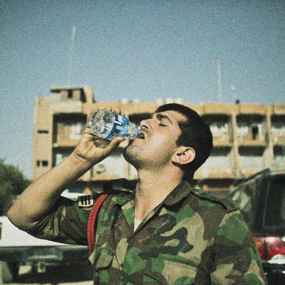 En soldat i det kurdiske forsvaret heller i seg drikke etter å ha overlevd nok en dag ved fronten. Varmen, tørken og støvet i området de kjemper er ekstrem.