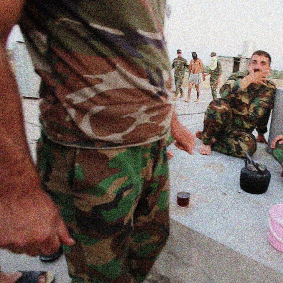 En fanget ISIL-opprører (i bakgrunnen) blir tatt med opp på taket for å bruke toalettet. Fangene blir fraktet bort fra basen i løpet av kort tid for å unngå angrep.