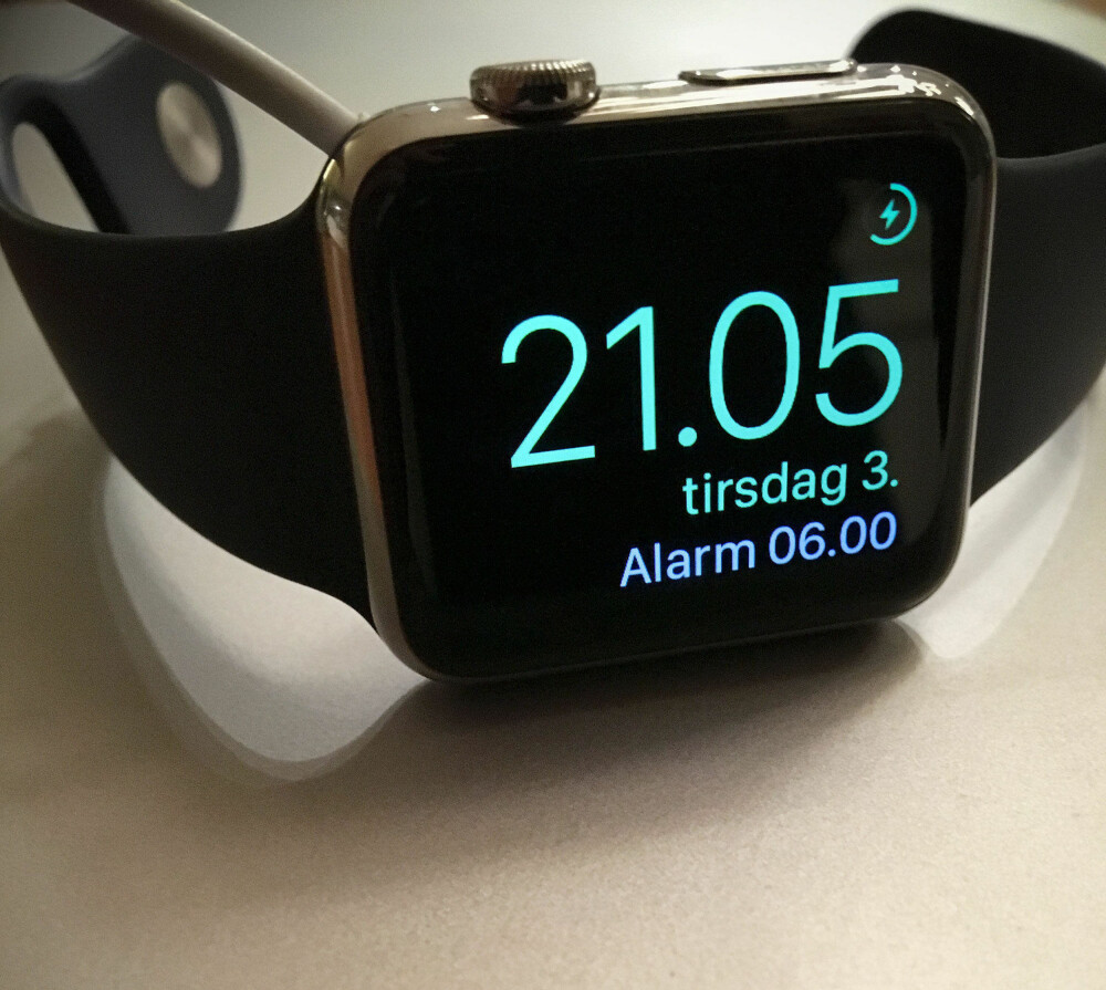 MÅ LADES HVER NATT: Batteriet på Apple Watch varer omtrent ett døgn, så i praksis må klokken lades om natten. Med ladekabelen i og vendt på siden, skifter displayet til vekkerklokkemodus.