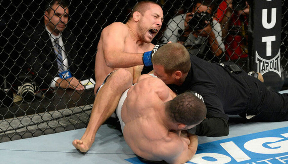 KONTROVERSIELL: Her er det Mike Pierce som får kjenne på Rousimar Palhares' heel hook.Dommer Kieth Peterson kaster seg inn for å få Palhares til å slippe grepet.