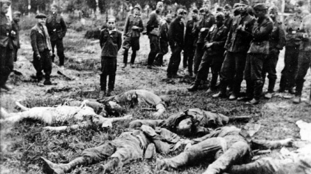 GRUSOMME HANDLINGER: De tyske dødsskvadronene Einsatzgruppen hadde som hovedoppgave å drepe sivile - også kvinner, barn og eldre. Innsatsgruppene står bak umenneskelige grusomheter. Bildet viser en tenåringsgutt i i Zboriv i Ukraina i 1941. Han blir fotografert ved siden av sin drepte familie øyeblikk før han selv blir skutt. Nazisten Helmut Oberlander (92) tjenestegjorde for Einsatzgruppe D. i Øst-Europa. De drepte om lag 23.000 sivile. Oberlander oppholder seg i dag i Canada.