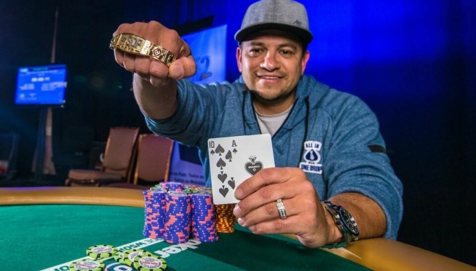 STOLT: Amerikanske Adrian Moreno viser stolt frem vinnerhånden til fotografen etter han slo norske Martin Lesjø i finalen i en pokerturnering i Las Vegas. Moreno er som Lesjø amatørspiller. I hånden har amerikaneren det meget ettertraktede gullarmbåndet kun vinnere i WSOP får.