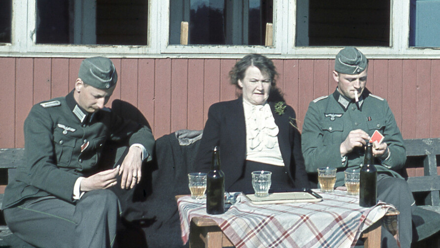 <b>MOT SLUTTEN: </b>Olga Bjoner fotografert i solveggen på ei hytte trolig i sør-Norge et sted, hvor hun nyter et glass sammen med to yngre offiserer. Bildet – som er sjeldent, fordi det er tatt i farger – er antagelig tatt i 1943 eller 1944, og viser en åpenbart sliten kvinne på nærmere 60.