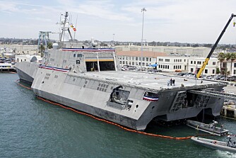 TIL KAI: USS Independence LCS 2 i ferd med å ta om bord en småbåt mens den ligger til kai ved USAs Navy Base i San Diego. Legg merke til hvor dominerende landingsdekket for helikoptrene er.